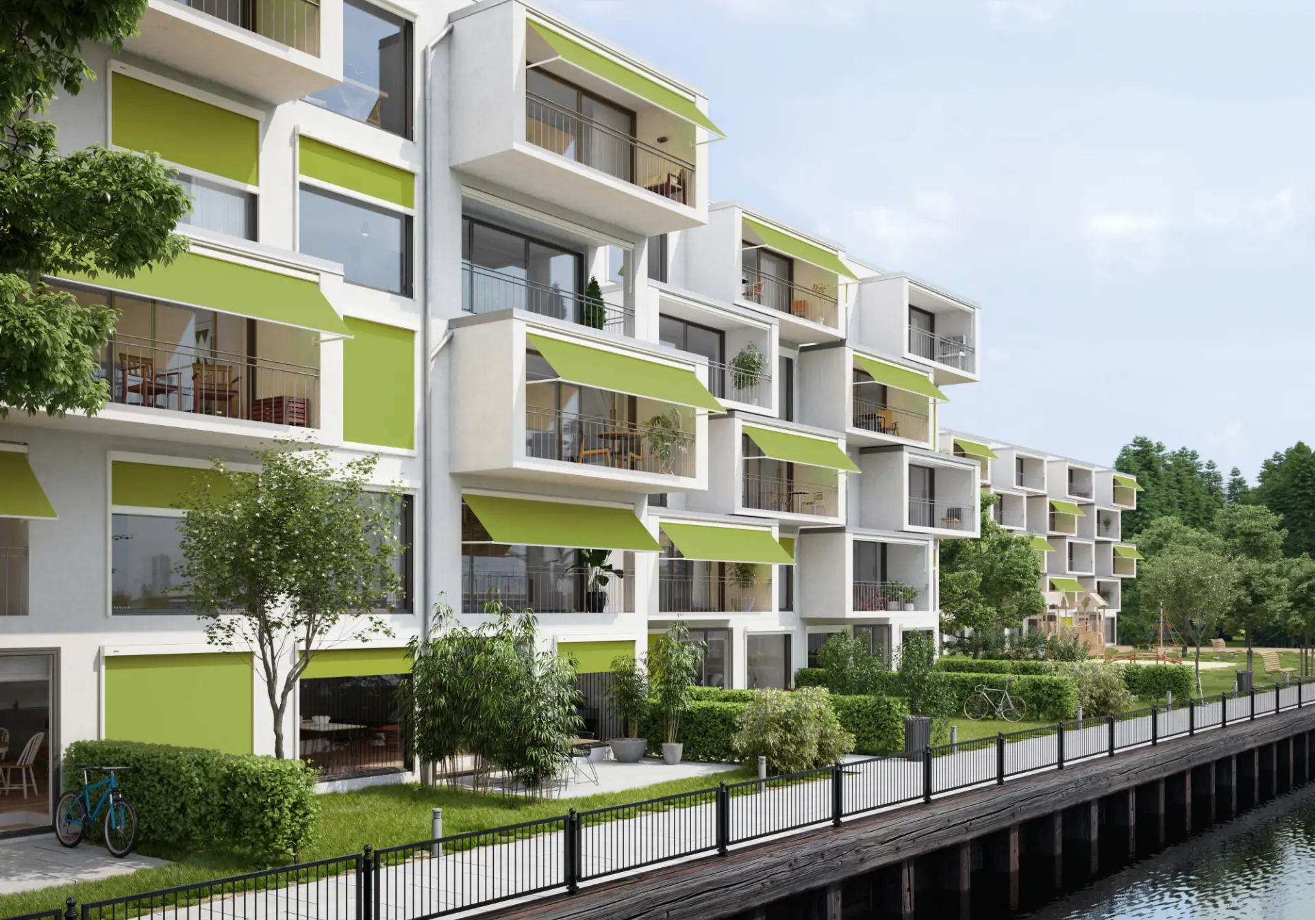 Grüne Fenster- und Balkonmarkisen über den Fenstern eines mehrgeschossigen Wohnhauses am Wasser
