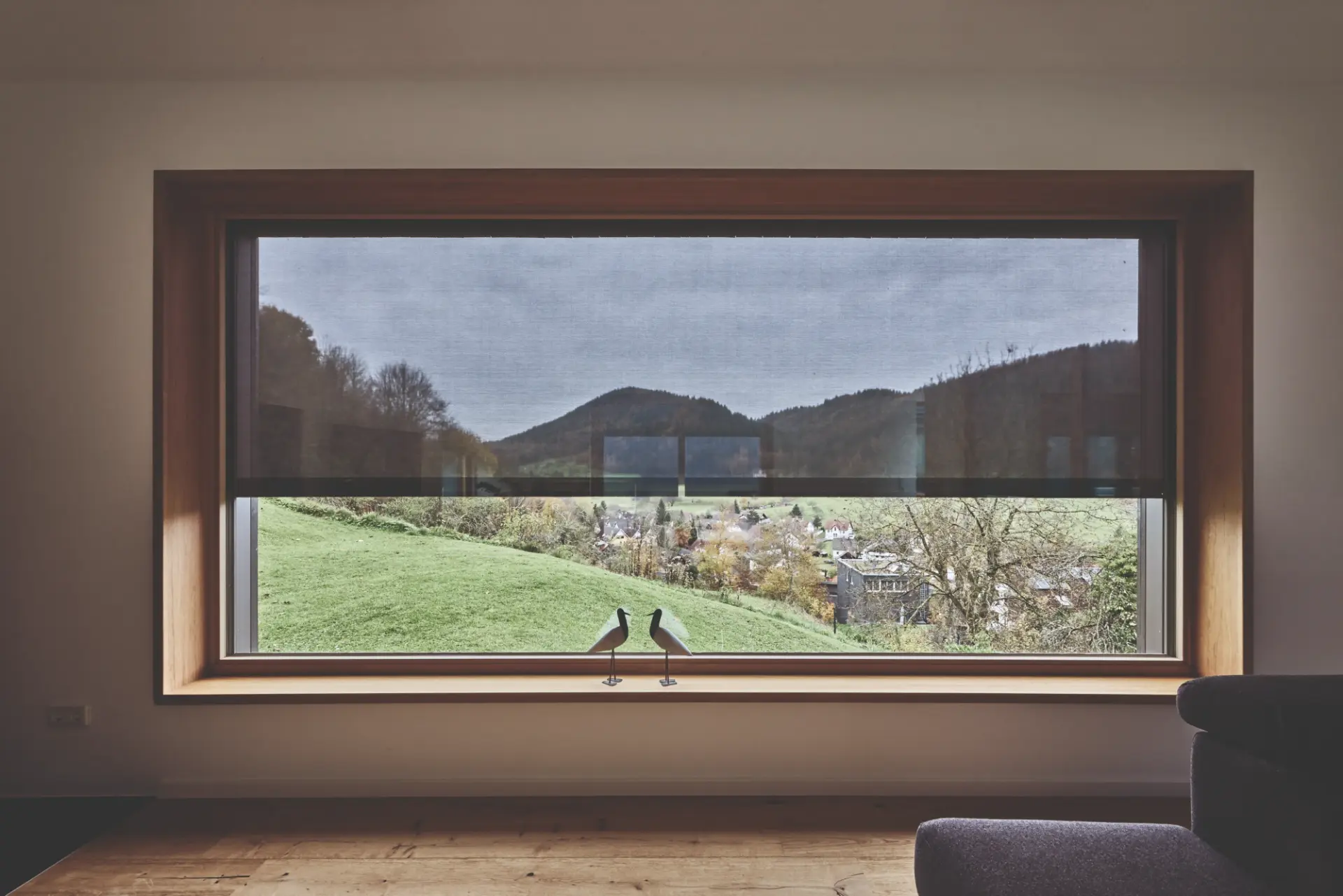 Zip-Screen halb heruntergefahren vor einem Panoramafenster mit Blick über ein Tal